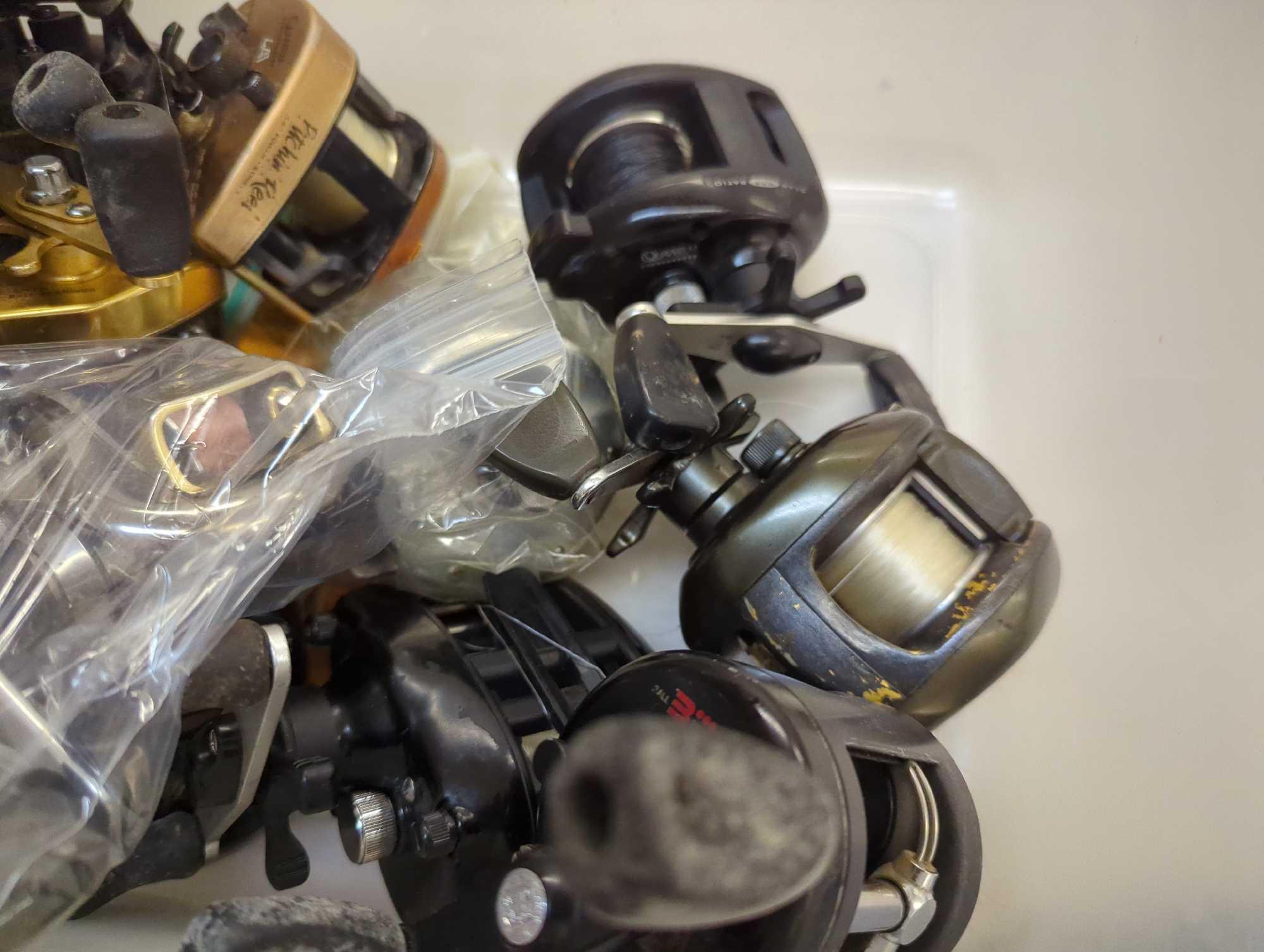 Clear tote and contents including various spinning reels. Comes as is shown in photos. Appears to be