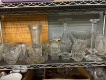 shelf full of glass early American press glass candlesticks dinner plates etc.